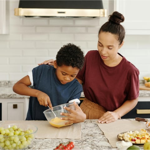 a woman and a boy in a kitchen