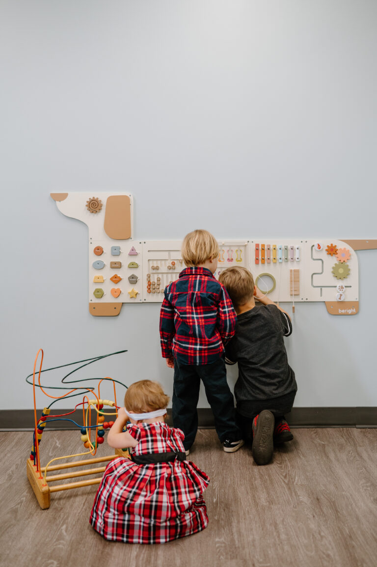 toddler separation anxiety — young child holding on to a parent's leg at daycare drop-off
